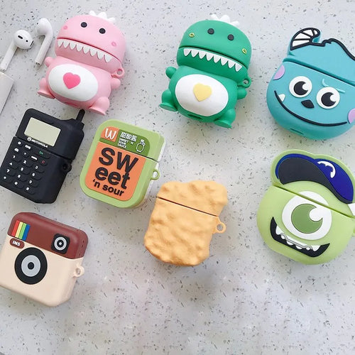Green silicone AirPods 1/2 generation case with a cartoon animal design on a table.