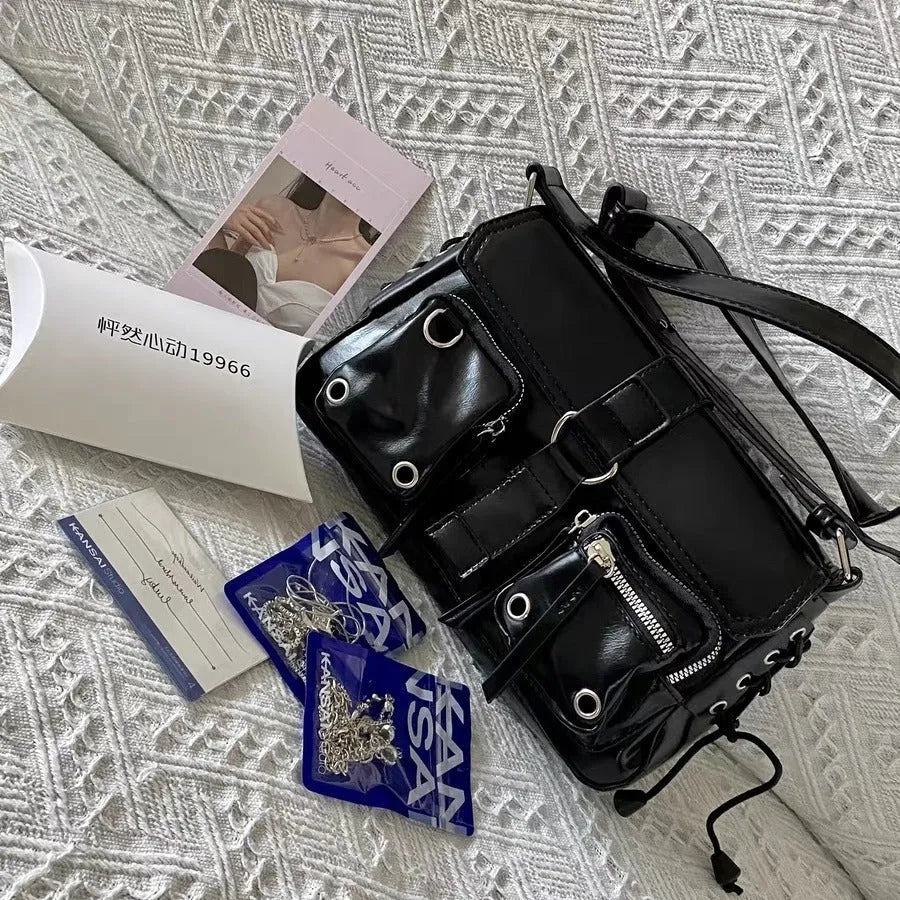 Black medium-hard PU women's baguette messenger bag with adjustable strap and zippered internal change compartment.