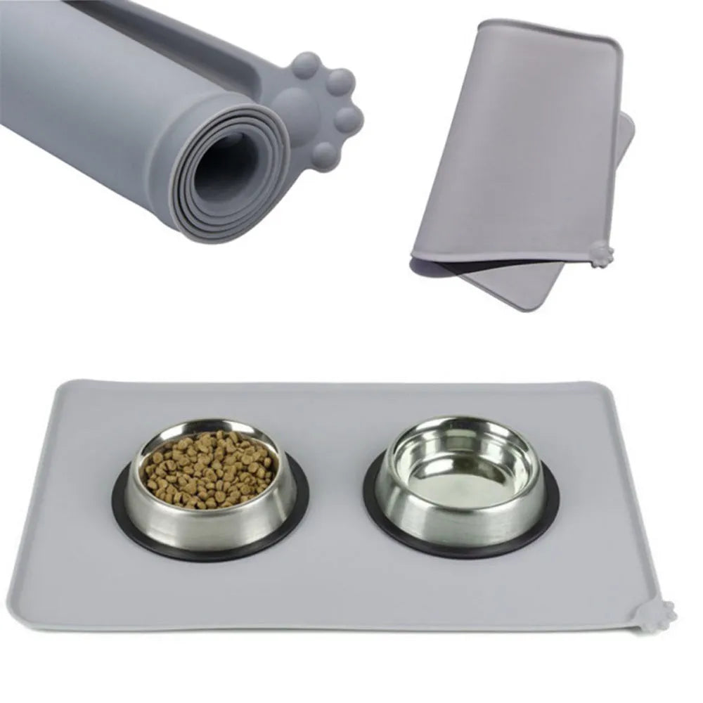 Grey silicone pet food mat with raised edges on a tile floor