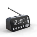 Black DAB bedside alarm clock with large LED display, pig tail antenna, and USB ports on a wooden table.