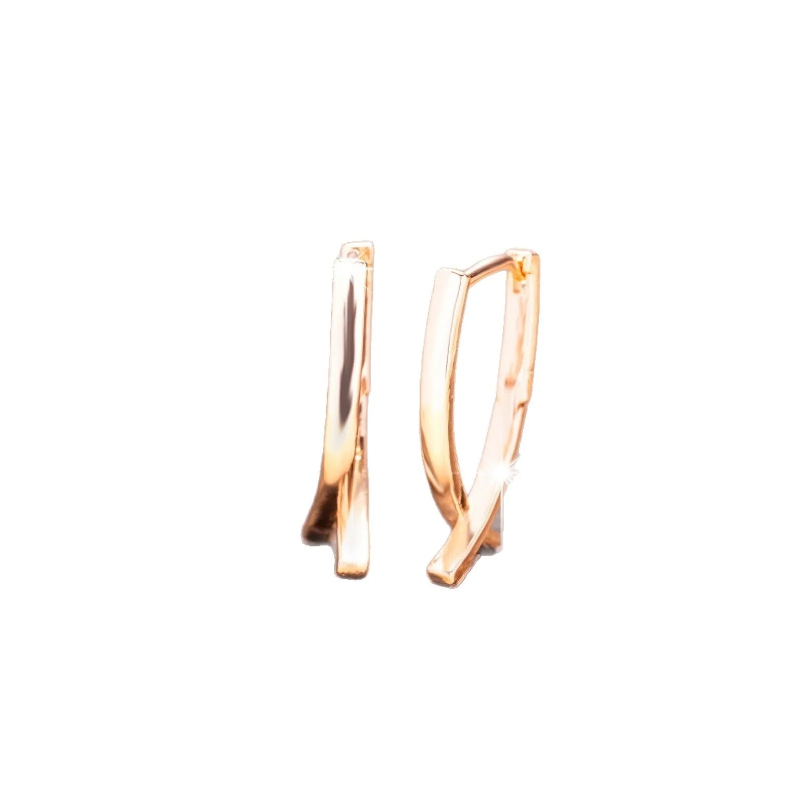 Rose gold cross shaped earrings on a plain background.