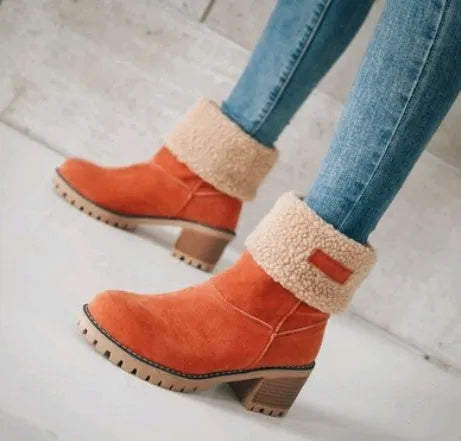 Women's black suede mid-tube snow boots with a thick heel and round toe on a waterproof platform.
