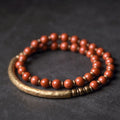 Layered ethnic bracelet with gemstone beads and brass details on a wrist, showing adjustable unisex design.