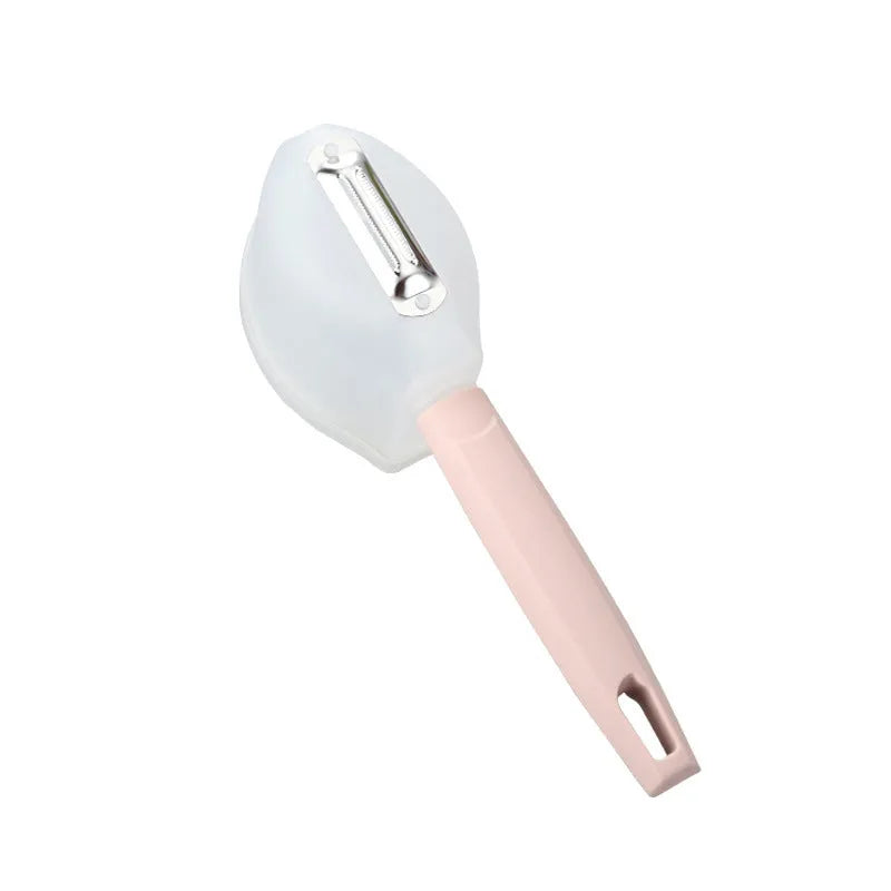 Stainless steel fruit peeler with pink PP plastic handle on a light background