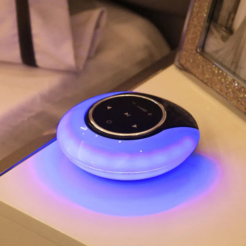 Blue and white Bluetooth speaker desk lamp with folded head on a wooden table, showing touch panel.
