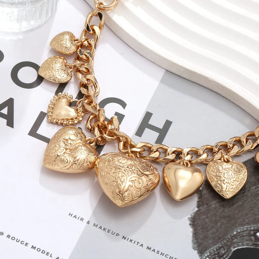 Carved heart-shaped pendant necklace on a metal chain, shown in gold and white K colour options.