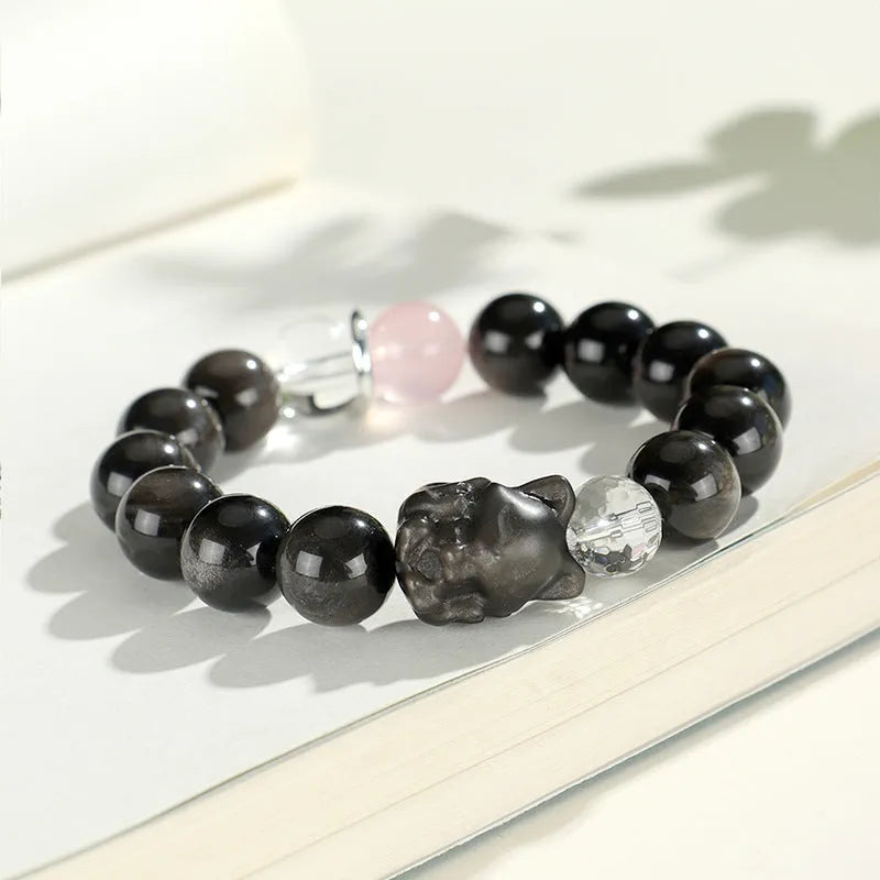 Silverstone crystal beaded bracelet with fox, cat head, and planet charms in white, pink, navy blue, and black.