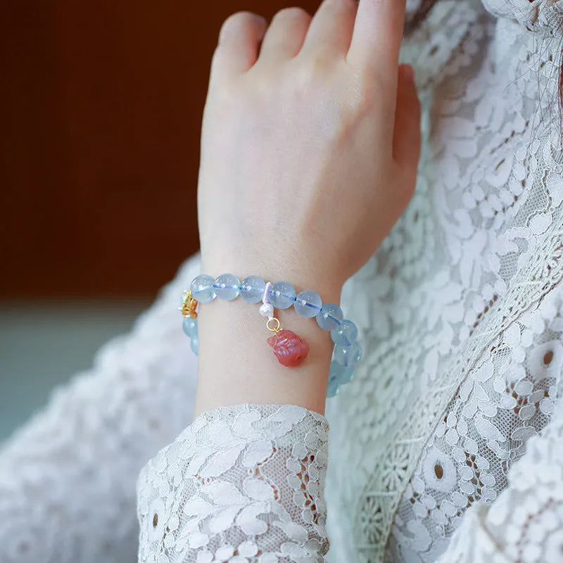 DIY kit components for an aquamarine fox Fengjiu bracelet with pearl and pink crystal beads.