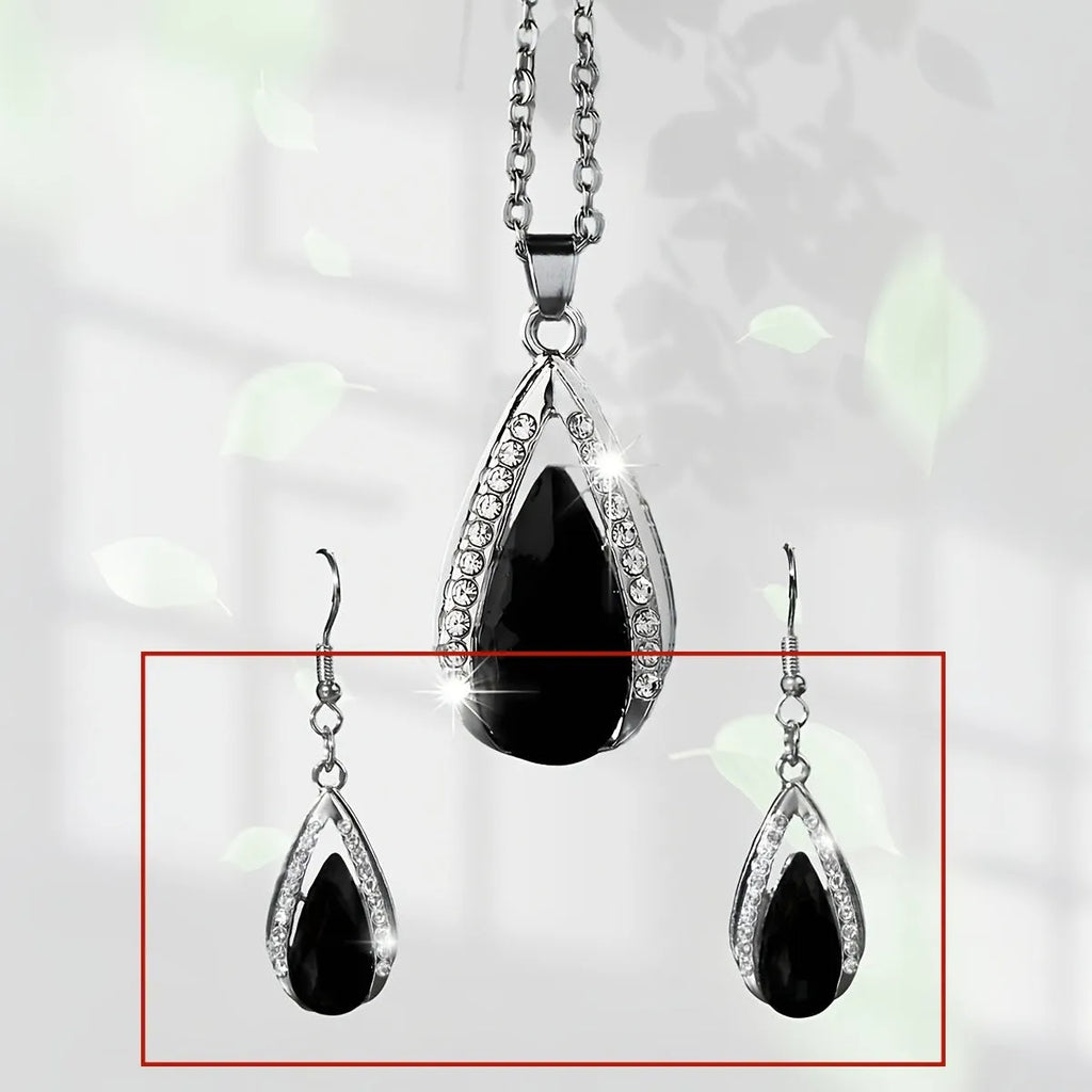 Black and red teardrop-shaped glass pendant necklace and matching stud earrings set on a grey background.