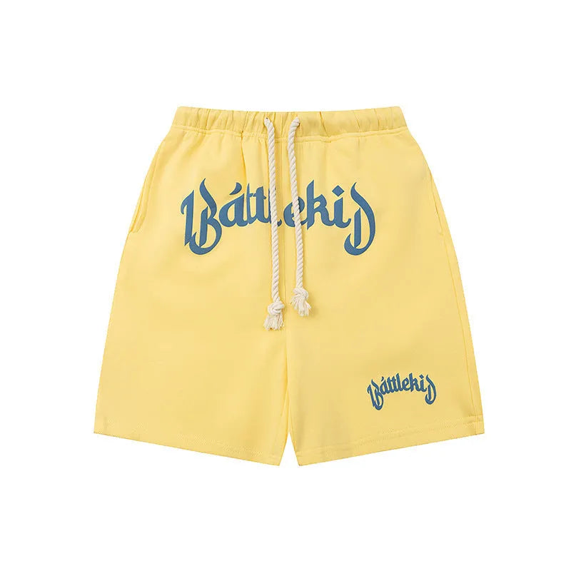 Men's black cotton loose-fit street style cropped shorts on a grey background.