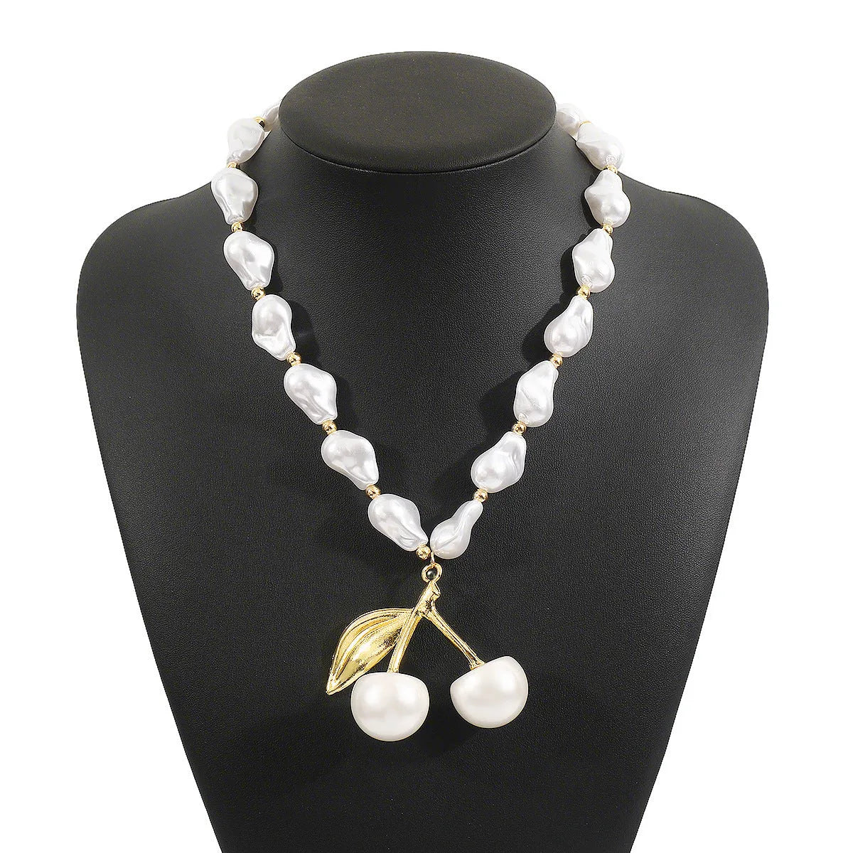 Gold irregular cherry fruit and pearl necklace on adjustable chain against white background.