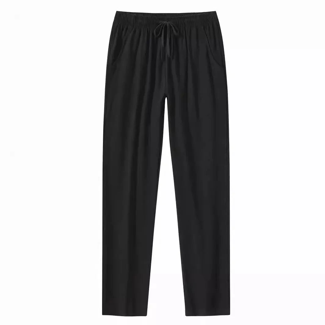 Men's loose-fitting cotton beach trousers in a solid colour, shown in a casual setting.