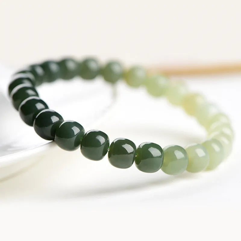Natural Hetian jade bracelet with sunny water gradient colour on a wrist, showing oval beads.