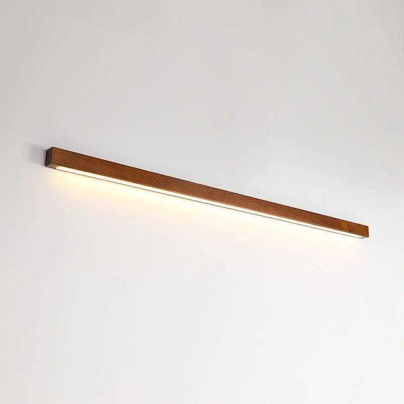 Modern walnut-coloured log strip wall lamp in three sizes on a white wall.