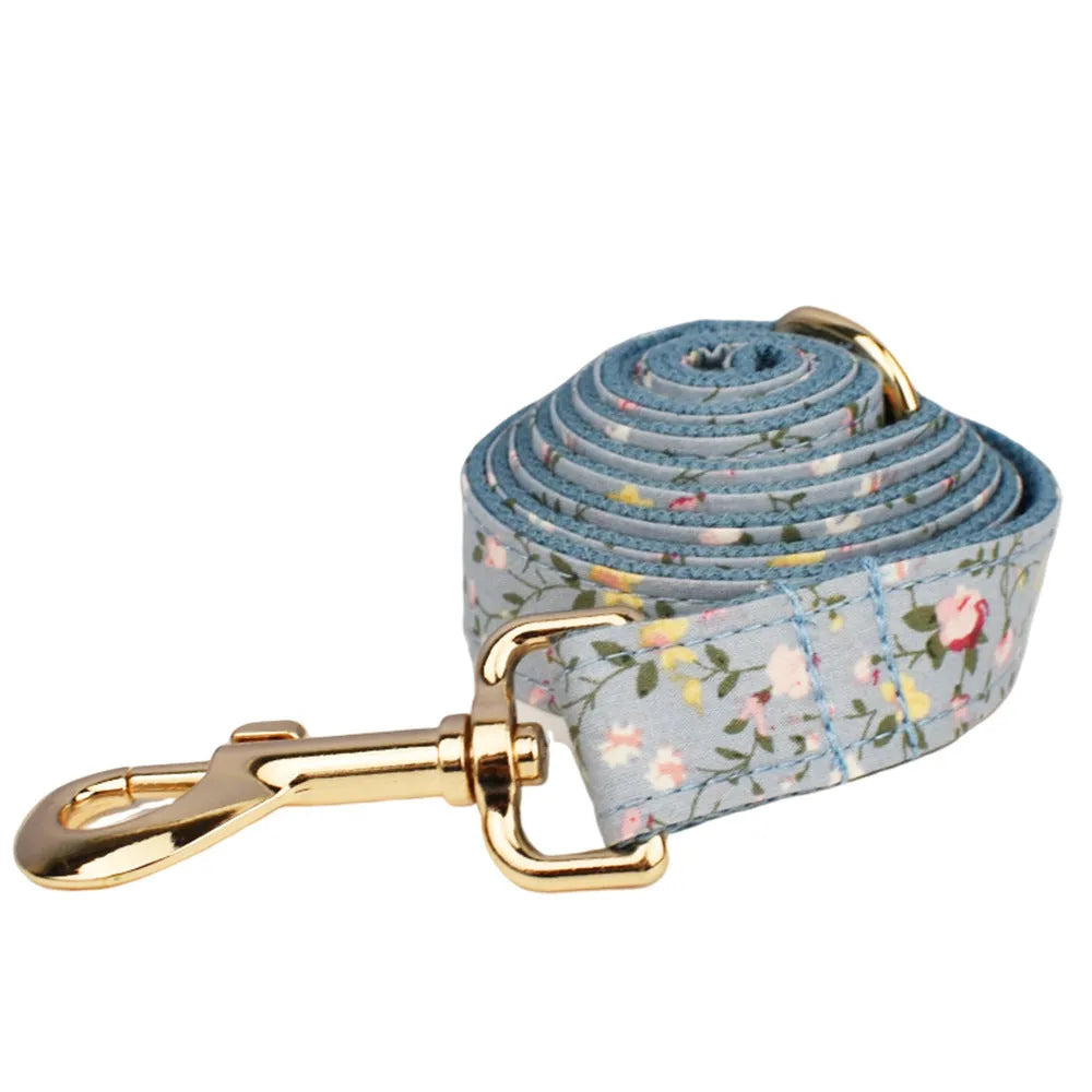 Blue floral dog collar and matching leash, bow, vest, and waste bag holder five-piece pet set.