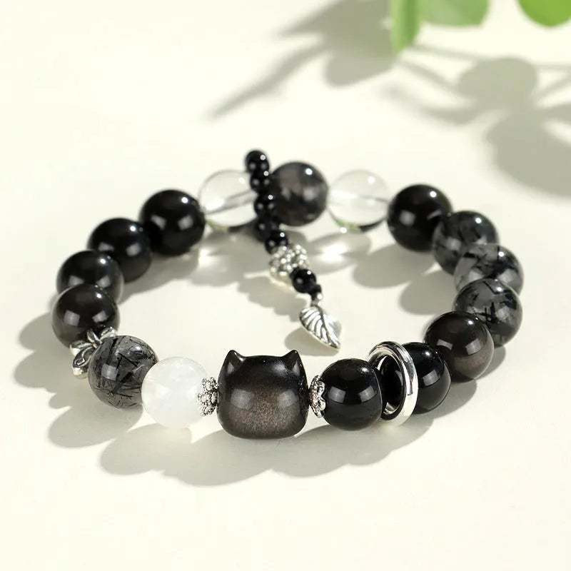 Silverstone crystal beaded bracelet with fox, cat head, and planet charms in white, pink, navy blue, and black.