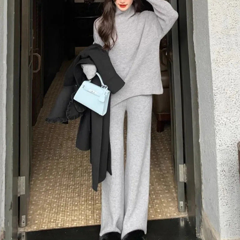 Women's beige acrylic sweater and wide-leg trousers two-piece set laid flat.