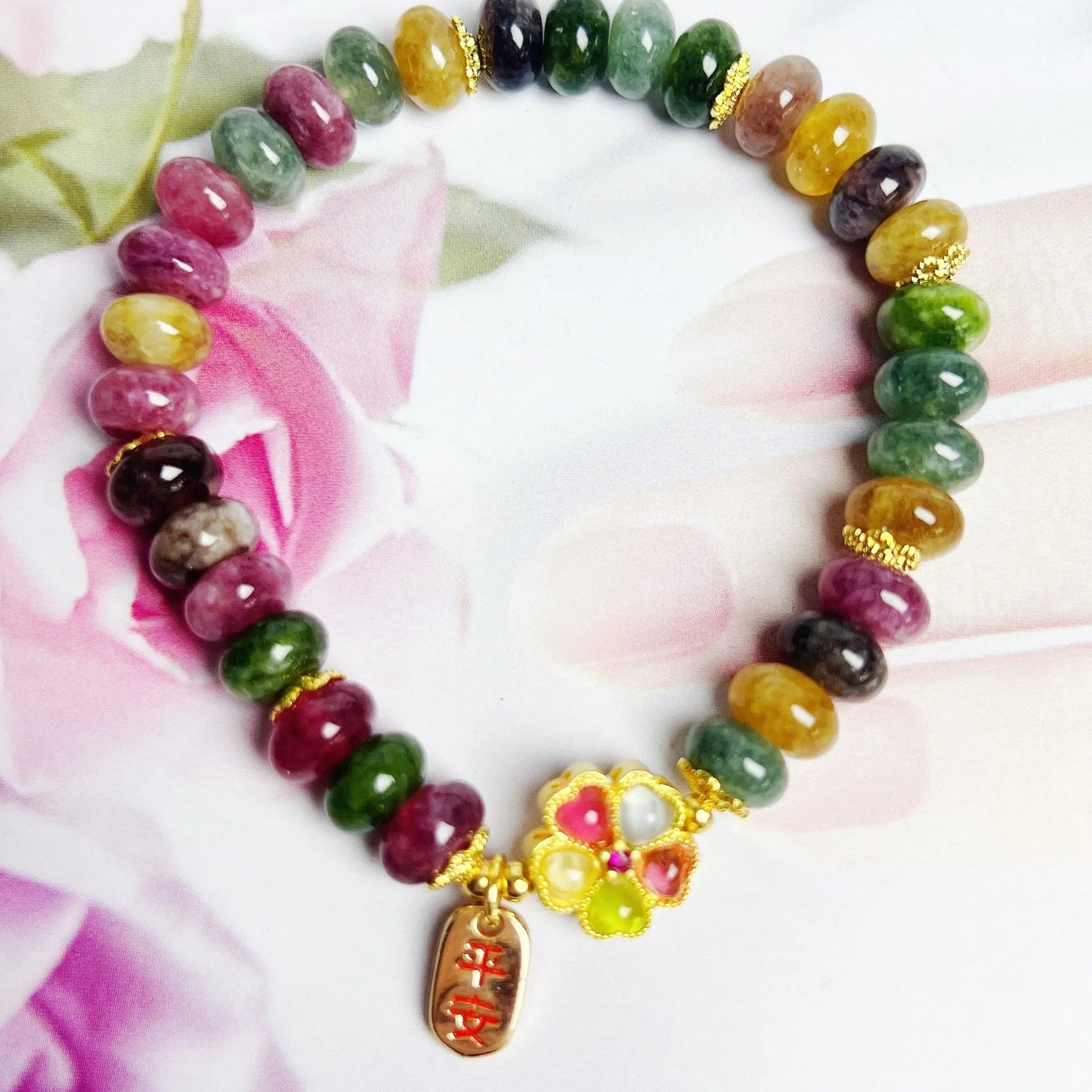 Women's bracelet with colourful tourmaline abacus beads and artificial crystal on wrist.