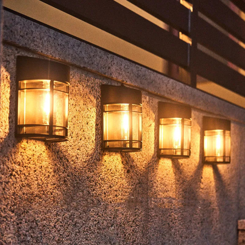 Solar-powered outdoor wall light with warm white LED, mounted on a garden wall.
