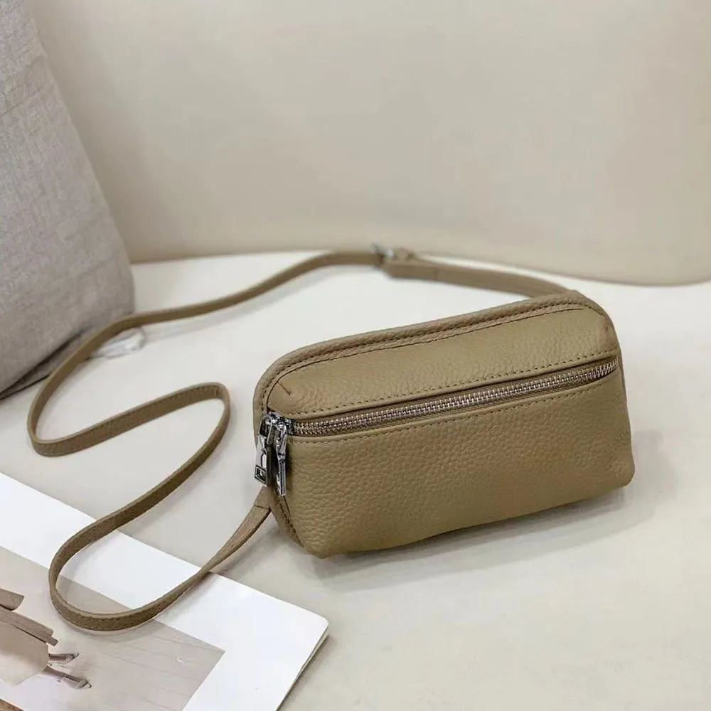 Mini crossbody bag in top grain leather with polyester lining, retractable handle, welt pocket, and solid colour patchwork design.