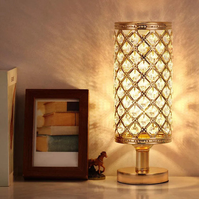 Modern crystal table lamp with hollow-carved design, metal base, gold finish, on bedside table