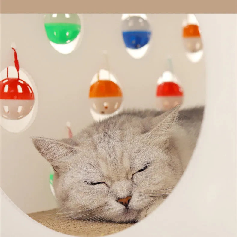 Grey integrated cat furniture with sisal scratching panel, plush-lined round nest, and tunnel with dangling bell ball toy.
