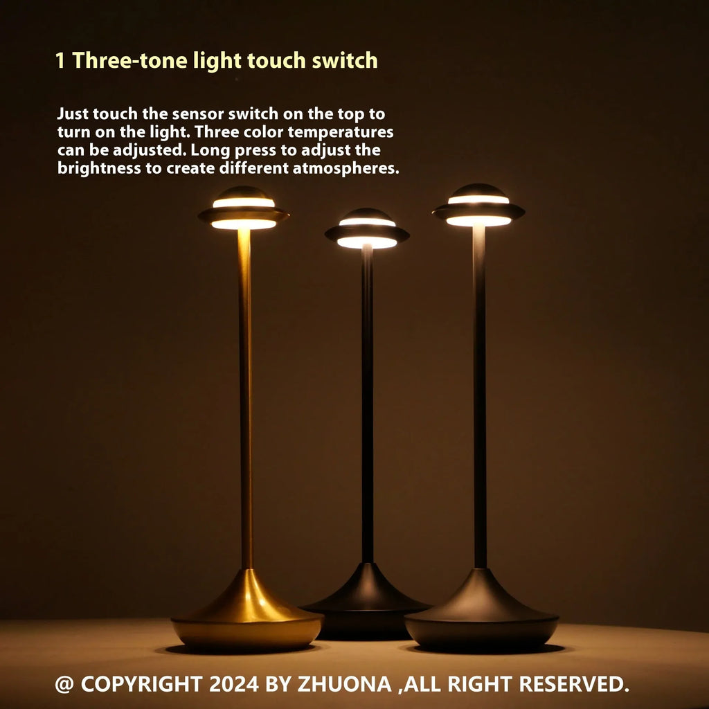 Modern UFO-shaped metal table lamp in black on a wooden desk, showcasing its rechargeable, touch-dimming design.