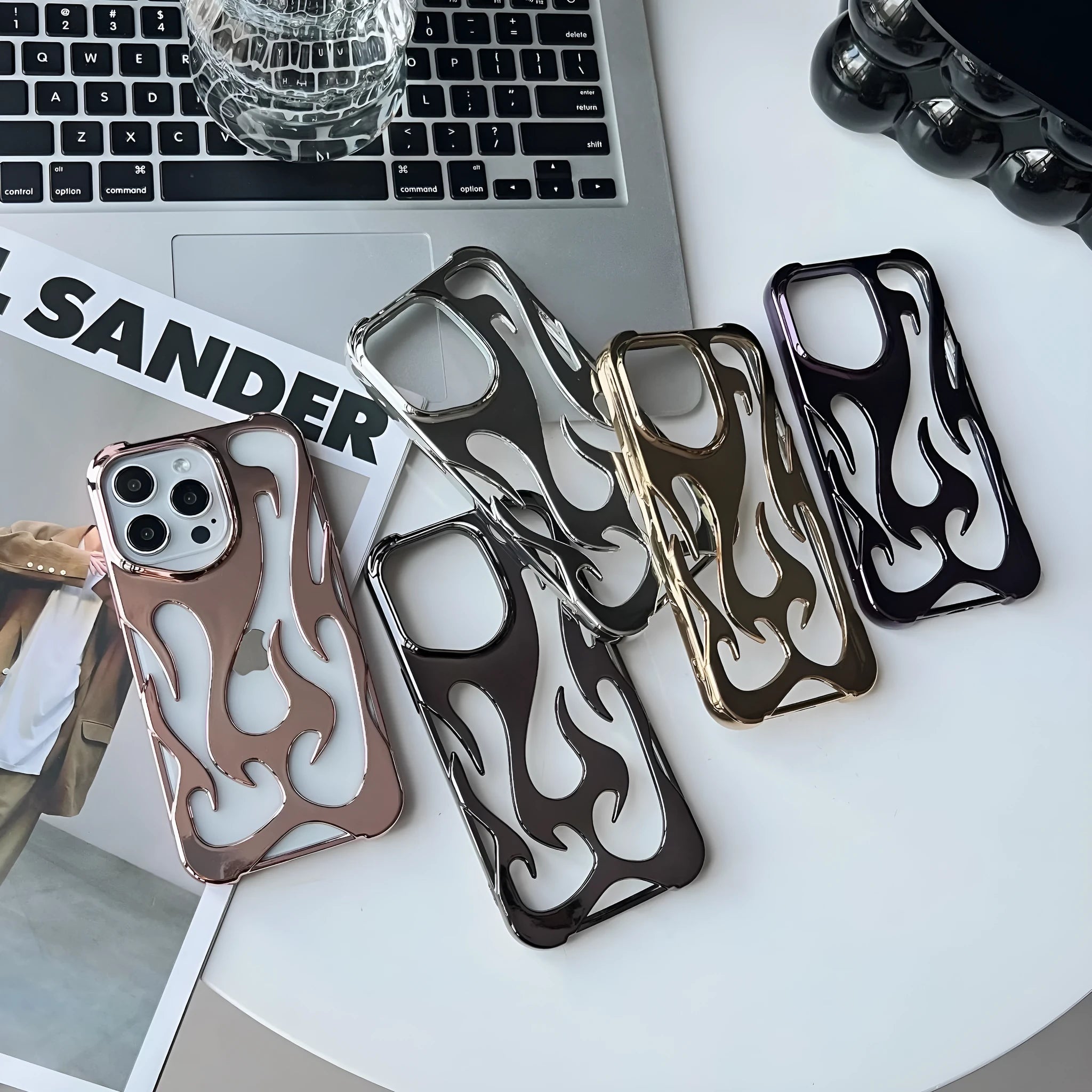 Silver electroplated iPhone case with hollow flame pattern design on a table