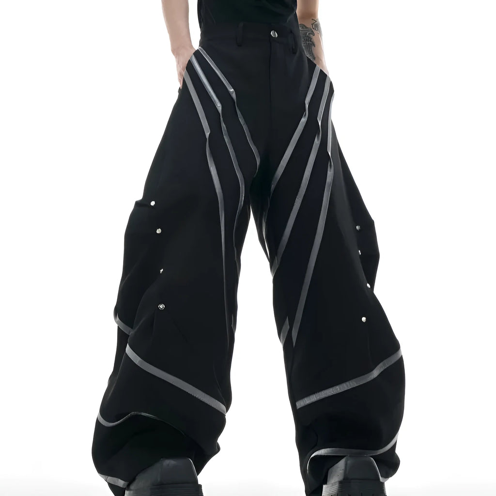 Men's black trousers with metal striped rivet and pleated detail on a three-dimensional cut.