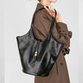 Black genuine leather large capacity bucket bag with visible stitching and crossbody strap on white background