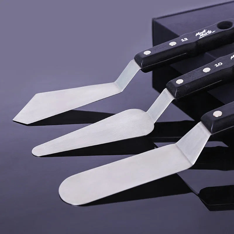 Three stainless steel oil painting palette knives, sizes No. 3, No. 10, and No. 12, on a surface.