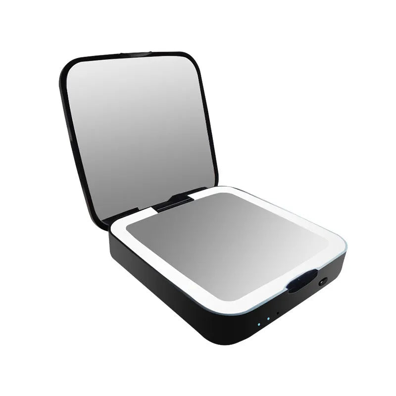 Black and white makeup mirror on table showing magnified and regular mirrors with illuminated ring light