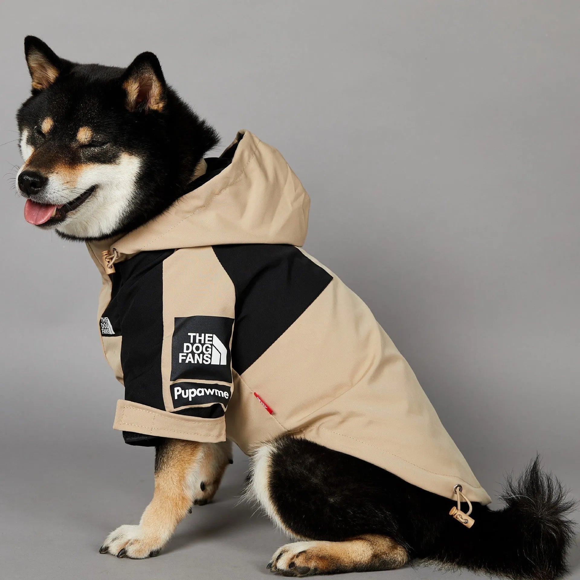 Khaki coloured polyester shell jacket for a dog on a white background.