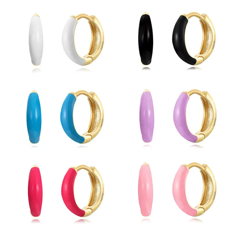 A pair of glossy, U-shaped epoxy oval earrings with a round ring detail on silver copper posts.