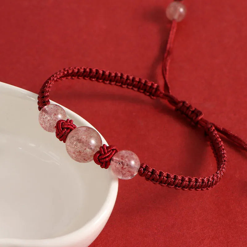 Woven red rope bracelet with strawberry quartz sphere beads and alloy detailing