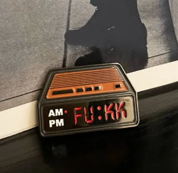 Black metal retro electronic alarm clock brooch pin with original design on a jacket lapel