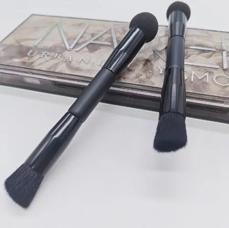 Black double-headed concealer brush with sponge end and tapered brush end on wooden handle