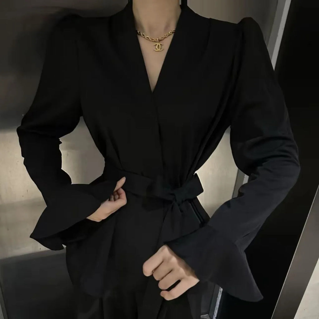 Women's black long sleeve shirt with an irregular collar and a tie closure at the neck.