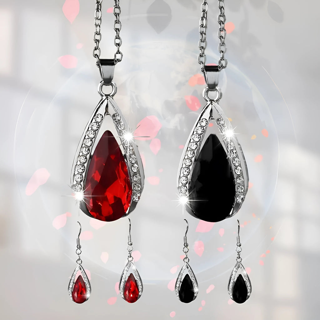 Black and red teardrop-shaped glass pendant necklace and matching stud earrings set on a grey background.