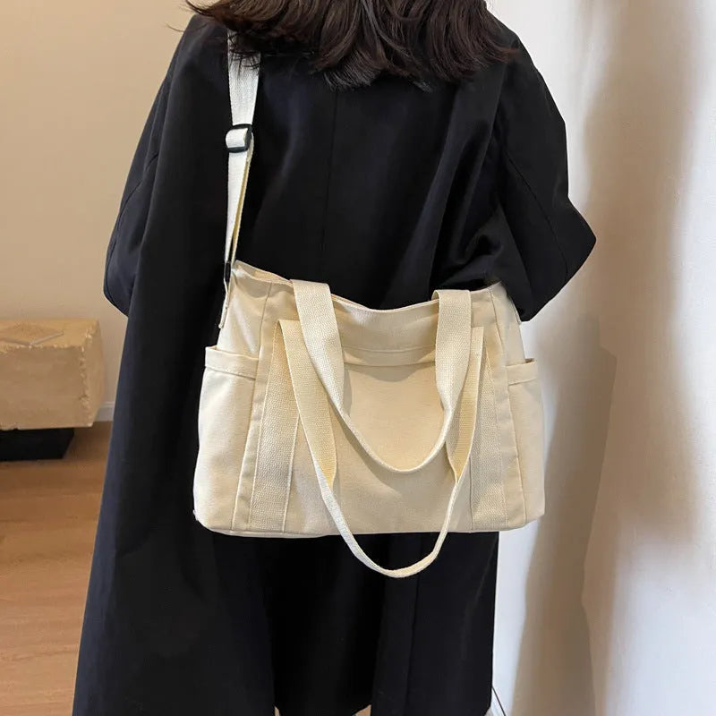 Large solid colour polyester canvas shoulder tote bag for women with outer pocket.