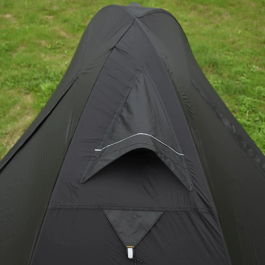 Single-person hiking tent in red pitched outdoors, showing aluminium poles and double-wall design with mesh inner.