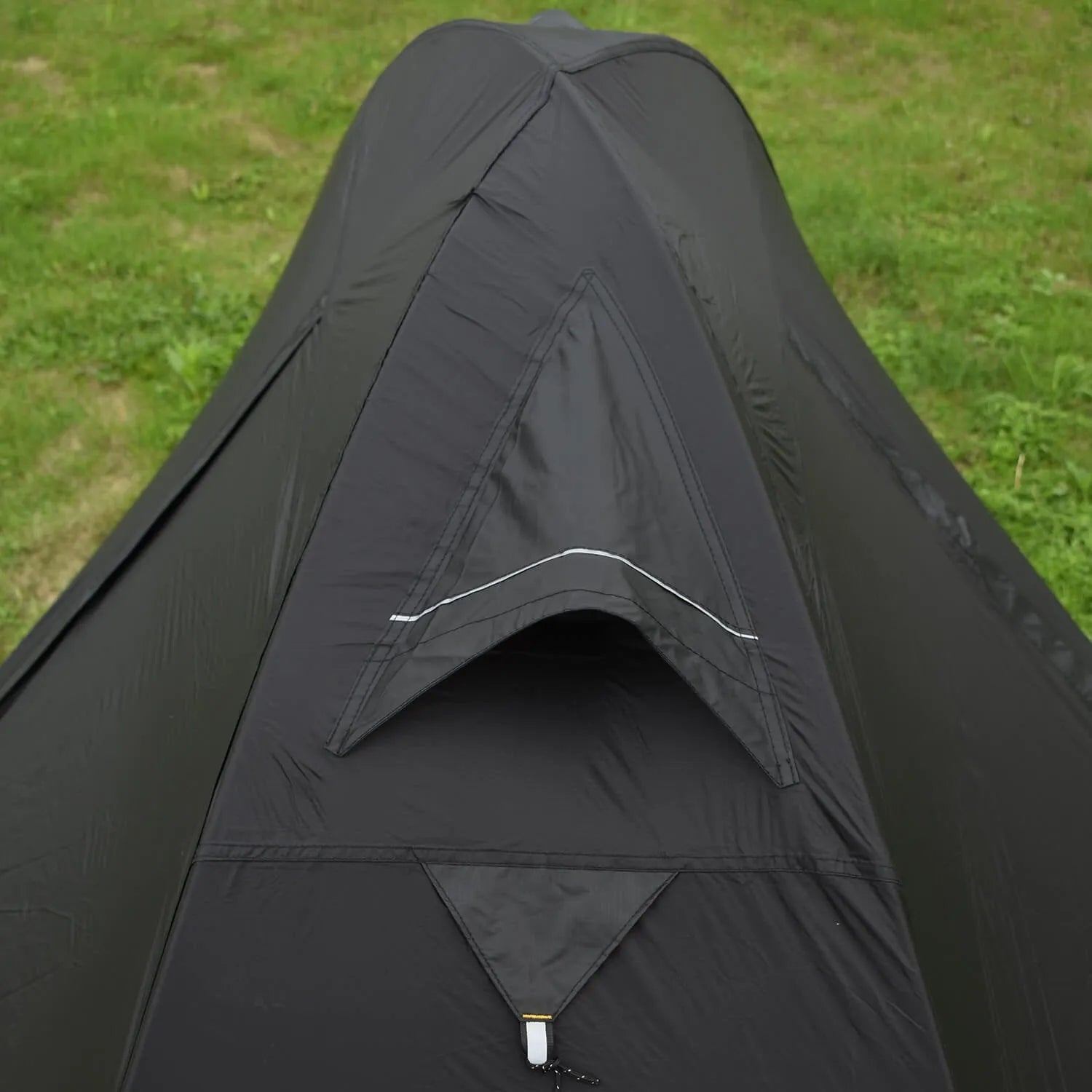 Single-person hiking tent in red pitched outdoors, showing aluminium poles and double-wall design with mesh inner.