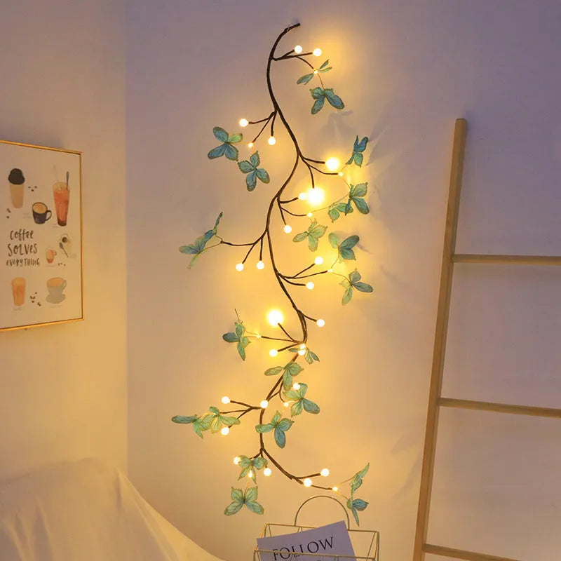 Tall flexible LED rattan tree lamp with colour-changing butterfly decorations lit up.