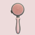 Green and pink dual-sided cat and dog brush with slicker comb and silicone massage head.