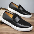 Men's black slip-on casual Gommino-style shoes with round toe and tassel decoration on a flat mid-heel.