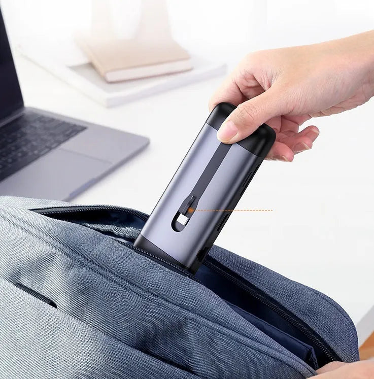 A USB hub expansion dock with HDMI, VGA, USB 3.0, Ethernet, and PD charging ports, with connected cables.