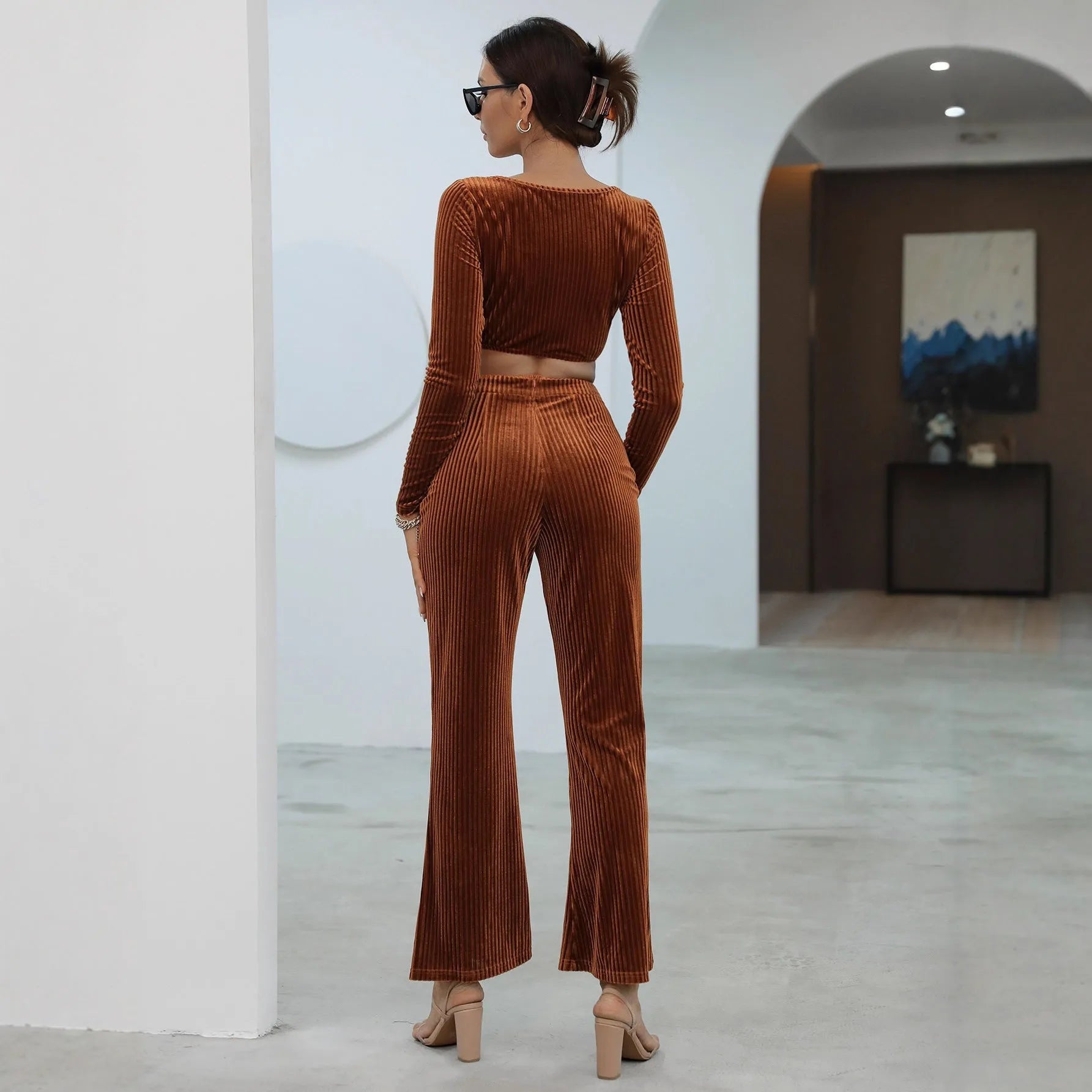 Caramel coloured long sleeve sweater and matching trousers set on a hanger.