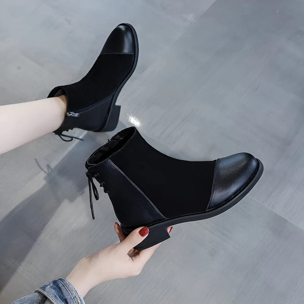 Black women's knee-high martin boots with side zipper and round toe on a rubber sole.