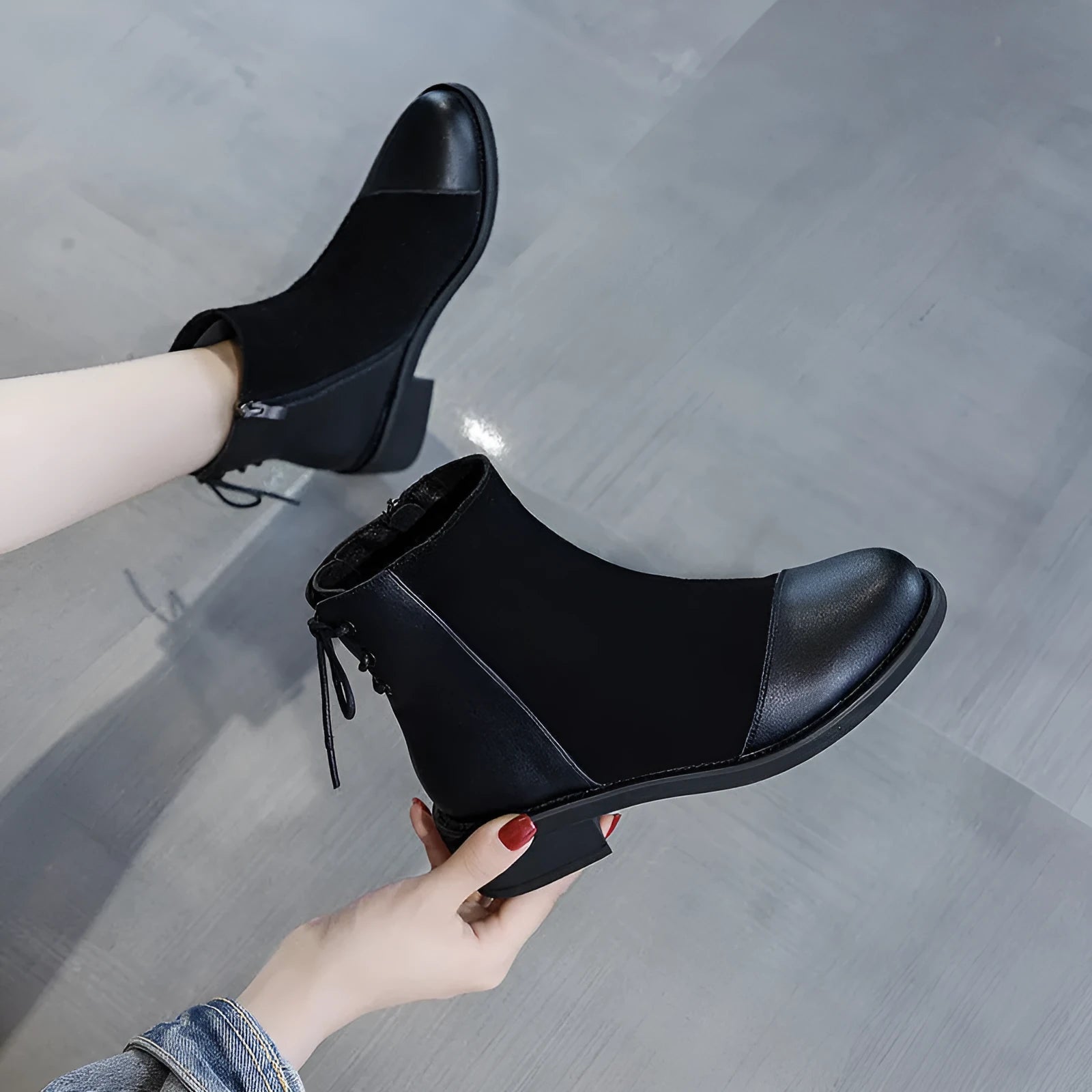 Black women's knee-high martin boots with side zipper and round toe on a rubber sole.