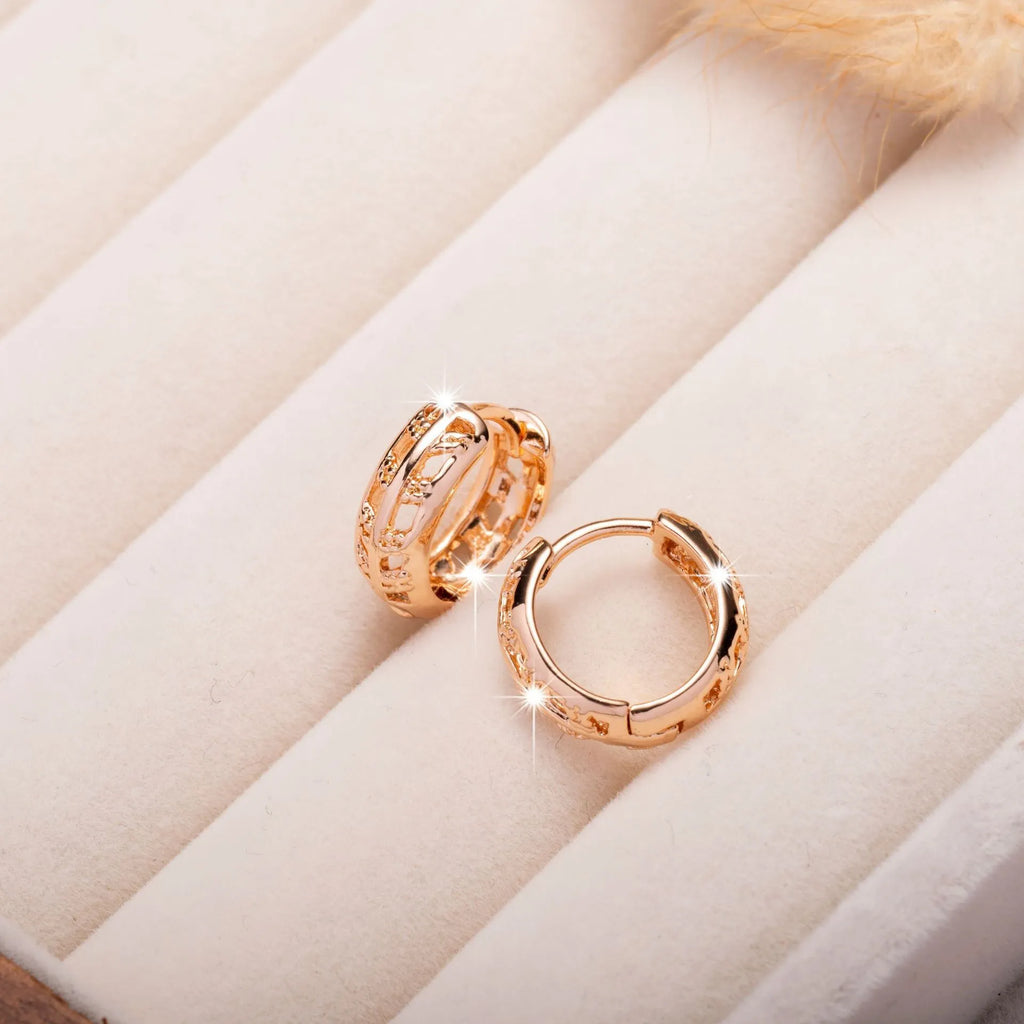 Rose gold plated copper earrings with hollowed-out heart and leaf shapes on a white background.